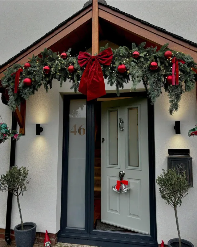 Christmas door garland with red bows around a front door